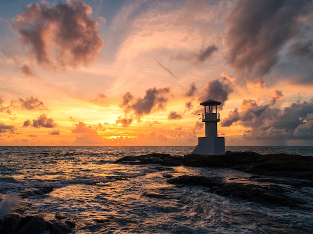 Faro nel mare e luce della sera.