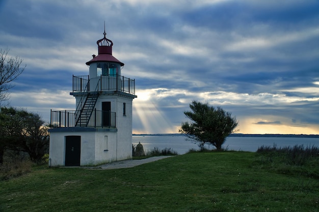 Faro Spodsbjerg Fyr a Huntsted, sulla costa della Danimarca Raggi di sole splendente