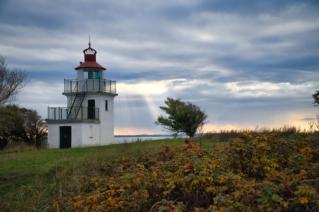 Faro Spodsbjerg Fyr a Huntsted, sulla costa della Danimarca Raggi di sole splendente