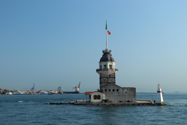 Faro sul mare contro gli edifici contro il cielo blu limpido