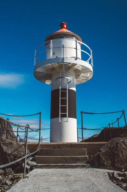 Faro sul molo sullo sfondo delle montagne e del cielo azzurro delle Isole Lofoten