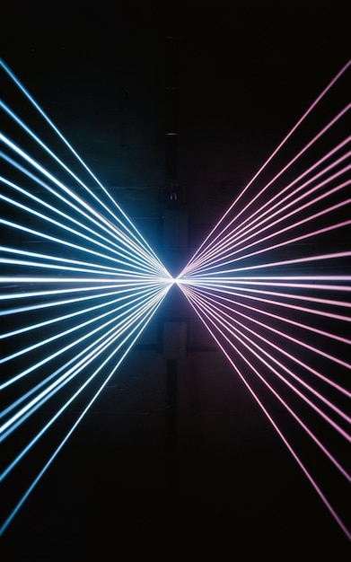 Fasci blu e viola di brillante luce laser che brillano su uno sfondo nero
