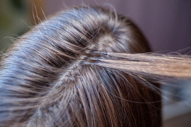 Fasci di estensioni dei capelli sulla testa di una donna Estensioni dei capelli per addensare le proprie ciocche individuali