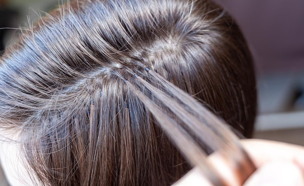 Fasci di extension per capelli sulla testa di una donna Extension per capelli per addensare le tue ciocche individuali