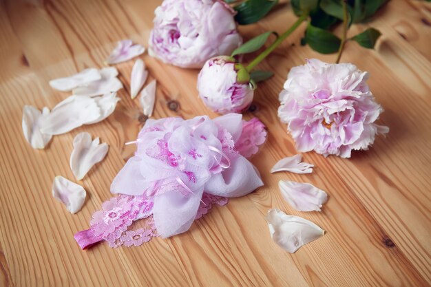 Fascia per capelli, fiore in tessuto e pizzo, perline con peonia su superficie in legno