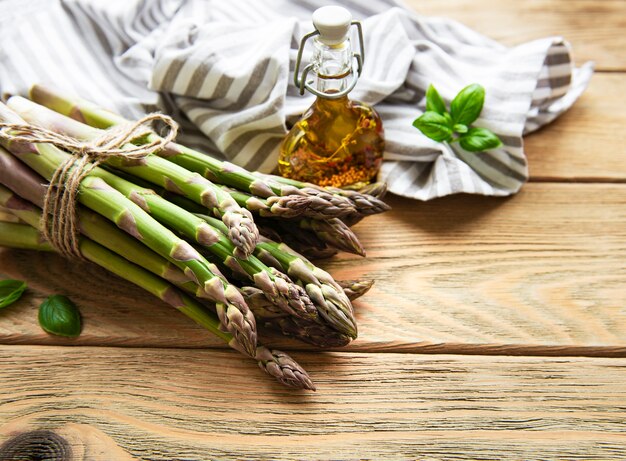 Fascio di asparagi verdi freschi su un tavolo in legno rustico, vista dall'alto