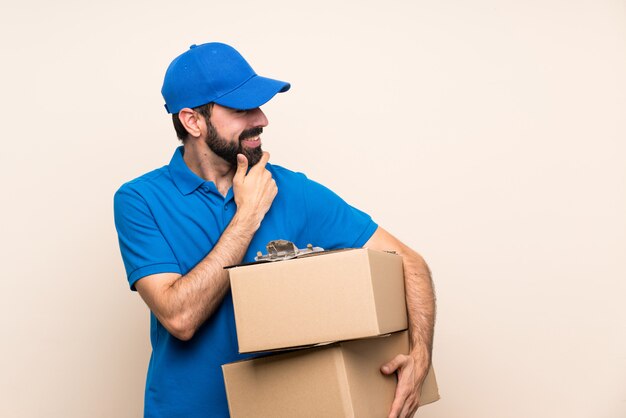 Fattorino con la barba sopra la parete isolata che guarda al lato