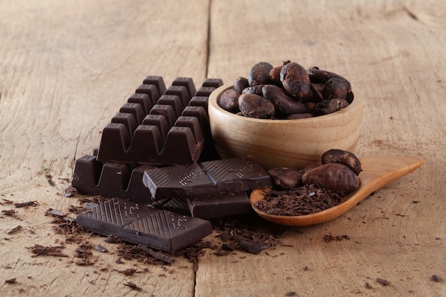 Fave di cacao crude, cioccolato su fondo di legno