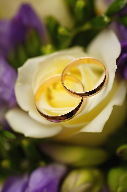 Fedi nuziali d'oro su un mazzo di fiori per la sposa