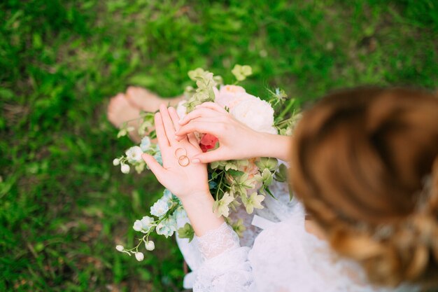 Fedi nuziali in una scatola di legno per anelli nelle mani della sposa