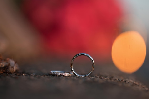 Fedi nuziali su una pietra con sfondo bokeh rosso