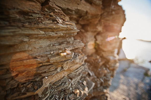 Fedi nuziali sulla pietra di roccia sul tramonto