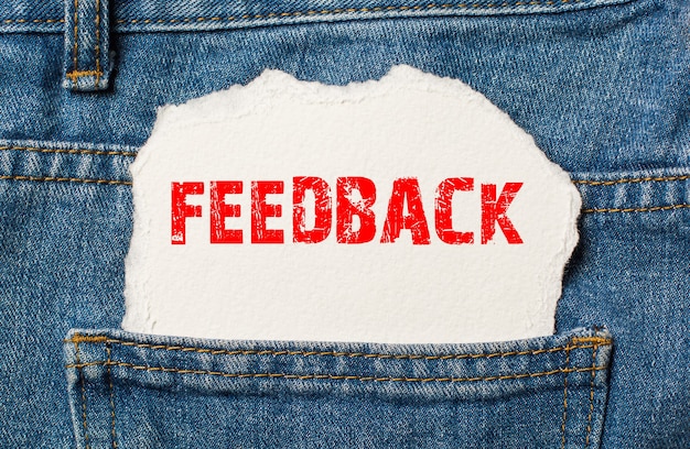 Feedback su carta bianca nella tasca dei jeans blu denim