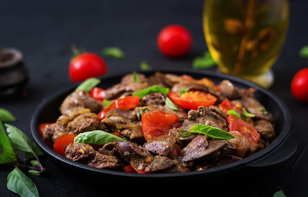 Fegato di pollo (frattaglie) con cipolle e pomodori in padella in armeno