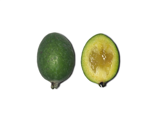 Feijoa matura su sfondo bianco Isolato di frutta verde Questo frutto dovrebbe essere mangiato con un cucchiaio Ingrediente succoso per il succo Feijoa a fette Intero e tagliato