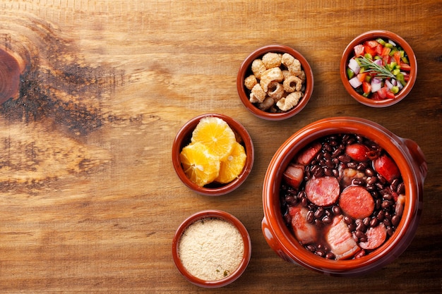 Feijoada brasiliana cibo tradizionale della cucina brasiliana su una ciotola di ceramica su un tavolo di legno rustico