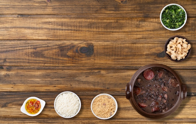 Feijoada brasiliana tradizionale con riso, cavolo riccio, farina di manioca, ciccioli e copia spazio.