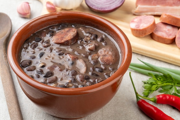 Feijoada brasiliana tradizionale in una ciotola con gli ingredienti.