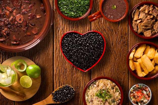 Feijoada brasiliano cibo. Vista dall'alto con pentola di fagioli cuore rosso.