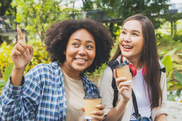 Felice amicizia tra due studentesse di educazione femminile di diverse nazionalità in giardino