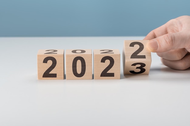 Felice anno nuovo 2023 concetto Capovolgimento del cubo di legno cambiamento del blocco dal 2022 al 2023 Inizia il nuovo anno 2023 con obiettivo piano obiettivo concetto piano d'azione strategia capodanno visione aziendale