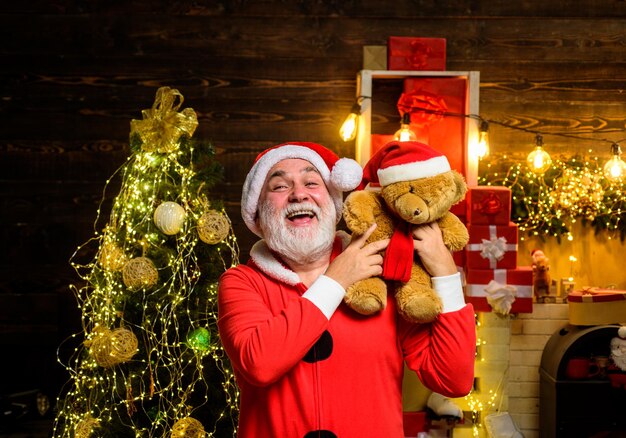 Felice anno nuovo babbo natale con l'orsacchiotto giocattolo buon natale vacanze natale babbo natale uomo tiene