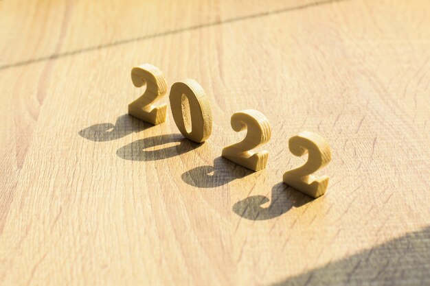 Felice anno nuovo concetto 2022 numero di legno su tavola di legno con ombre