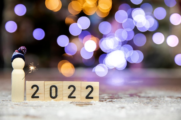 Felice anno nuovo numero scritto scintillanti stelle filanti bengala con sfondo colorato bokeh con copia sp...