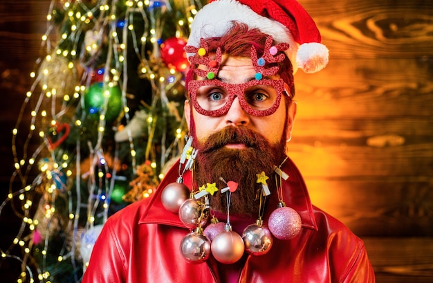 Felice Babbo Natale vestito con i vestiti d'inverno pensa al Natale vicino all'albero di Natale Ritratto di un Babbo natale concetto di nuovo anno Casa atmosfera di Natale