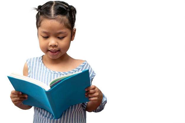 Felice bambina asiatica in età prescolare che tiene in mano e legge un libro su sfondo bianco isolato