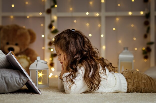 Felice bambina bambino sta leggendo il libro di fiabe