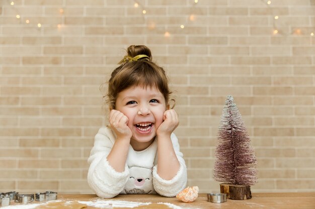 Felice bambina con albero di NataleSfondo muro di mattoniStile minimalistaLuce di Natale