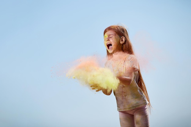 Felice bambina lancia vernici luminose