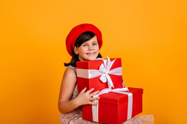 Felice bambino caucasico che tiene regali Studio shot di una bambina ridente che festeggia il compleanno