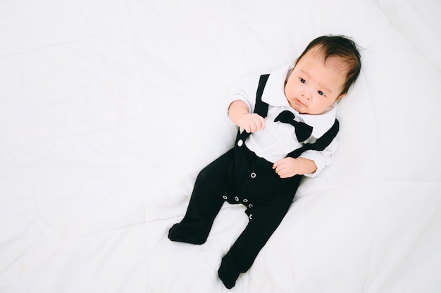 Felice bambino di 2 mesi. Ragazzino in camicia bianca e farfallino. Ritratto di bambini Elegante uomo alla moda in smoking smoking.