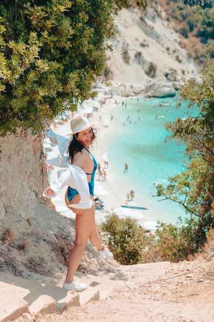 Felice bella donna che va alla spiaggia del mare