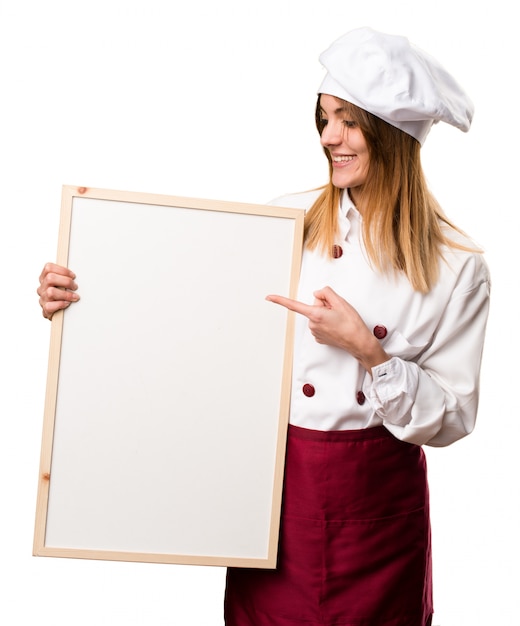 Felice bella donna chef tenendo un cartello vuoto