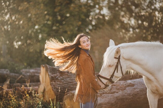 Felice bella femmina fantino con cavallo bianco.