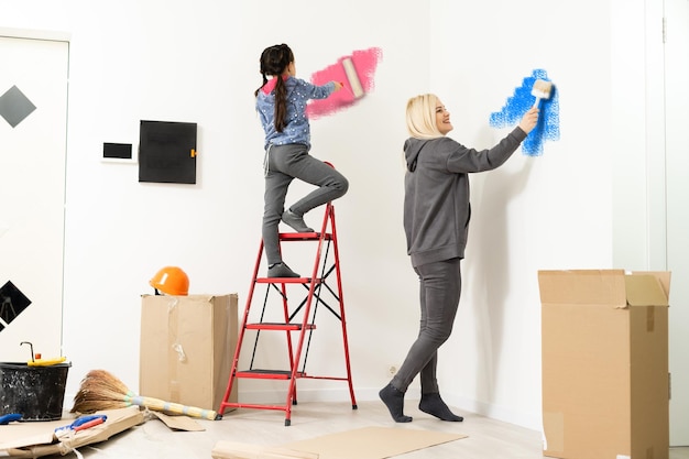 Felice bella giovane donna che fa pittura murale.