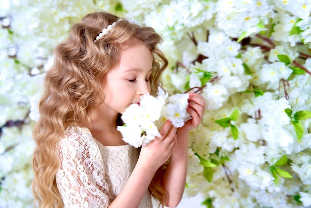 Felice bella ragazza bionda carina bambino bambino in giardino fiorito alberi di mele