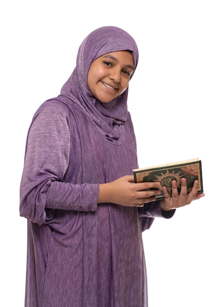 Felice bella ragazza musulmana araba in abito moda islamica tenendo il libro sacro del Corano, isolato su sfondo bianco