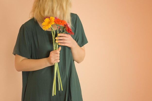 Felice bella timida giovane donna con fiori Giovane ragazza bionda sorridente godendo di un mazzo di fiori