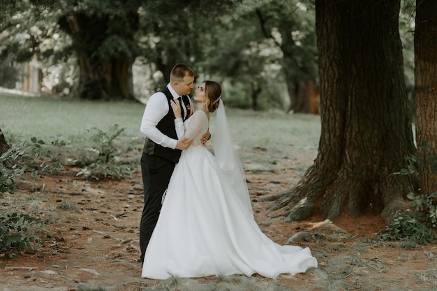 Felice bello sposo e bruna bella sposa in abito bianco