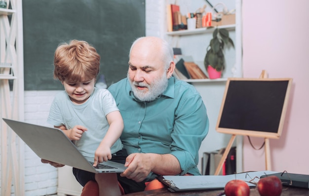 Felice carino ragazzo intelligente e vecchio tutor con libro Ritratto di fiducioso vecchio insegnante maschio Apprendimento ed ed