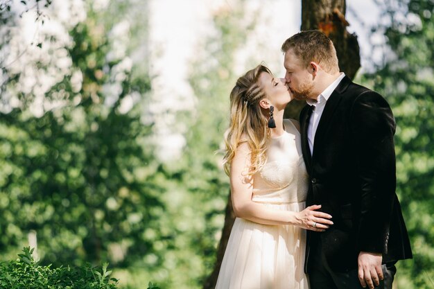 felice caucasica sposa e sposo che si baciano in giardino