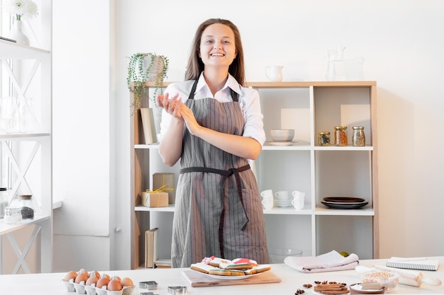 Felice chef femminile blog culinario pasticceria di pan di zenzero donna sorridente cuoco grembiule stare in cucina con