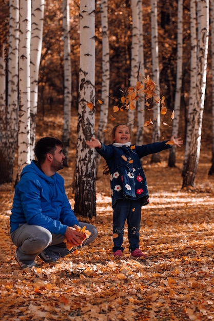 Felice concetto di famiglia uomo in giacca blu e pantaloni sportivi grigi si siede e guarda la bambina carina in blu...