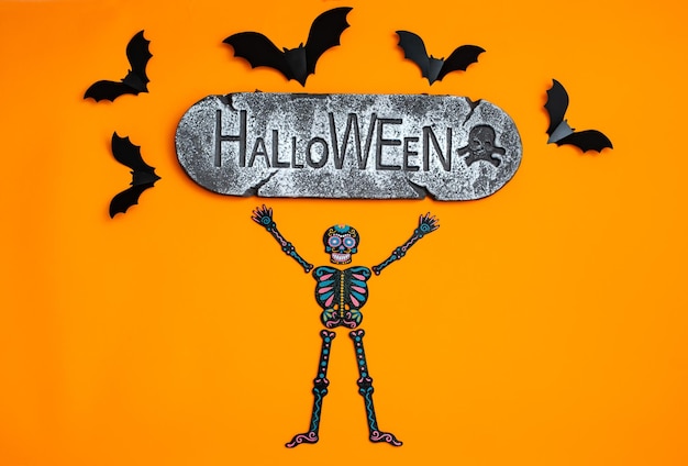 Felice concetto di vacanza di Halloween Halloween sfondo arancione design decorazioni pipistrelli modelli su scheletri segno che dice Halloween
