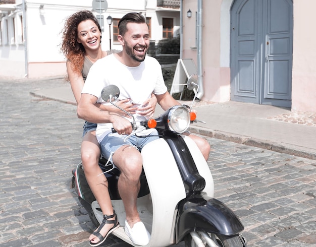 Felice coppia allegra in sella a uno scooter vintage all'aperto