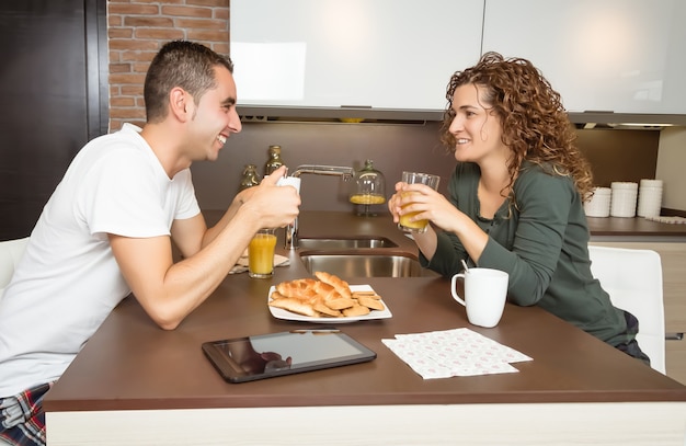 Felice coppia d'amore che parla a colazione a casa